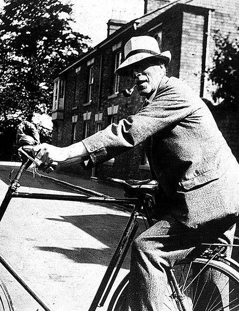 A photograph of Cecil Sharp, folk song gatherer on his bicycle